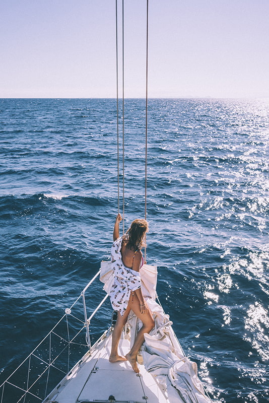 Femme a l'avant d'un bateau sur la mer